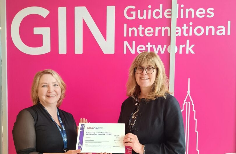 Two people stand in front of a pink wall, which reads "GIN, Guidelines International Network". They are holding a certificate. On the right is Roberta James, Programme Lead at SIGN