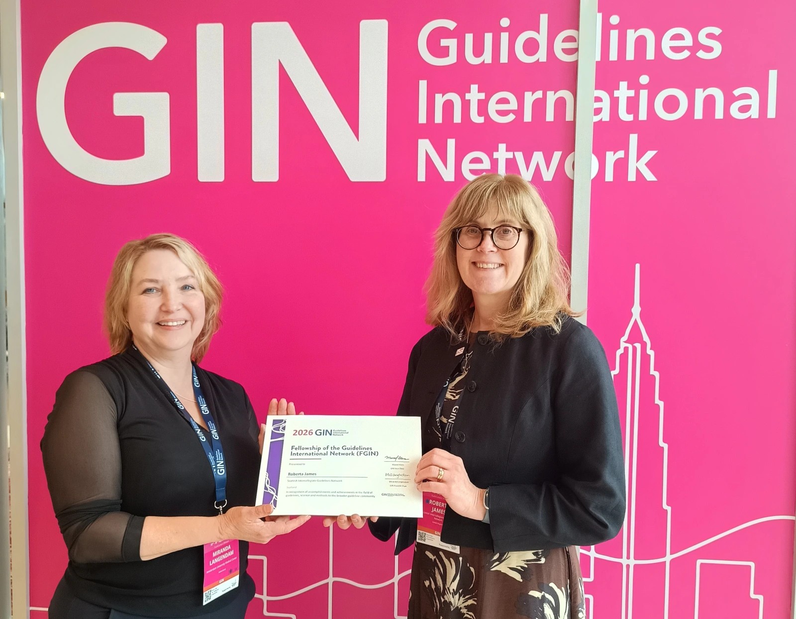 Two people stand in front of a pink wall, which reads "GIN, Guidelines International Network". They are holding a certificate. On the right is Roberta James, Programme Lead at SIGN